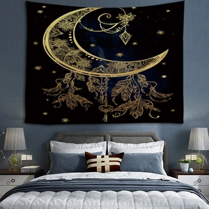 Détail d'une tapisserie bohème noire et dorée avec lune mandala suspendue dans une chambre