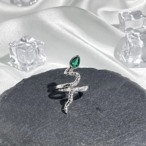 Detailed shot of silver snake ring with green teardrop gem and realistic scale texture