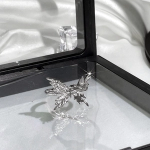 Macro shot of a silver butterfly ring with textured wings on a luxury display base