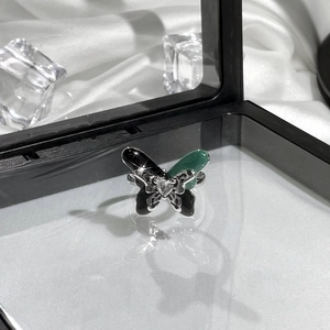Detailed macro view of butterfly ring featuring black and green enamel with a heart zircon