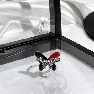 Close-up of butterfly ring with red and black enamel wings and silver metal band