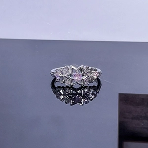 Detailed shot of star-shaped silver ring featuring a pink gemstone and micro-pave diamonds