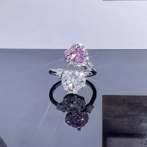 Macro detail of bypass ring with heart shaped pink and white gemstones in halo setting
