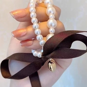 Elegant pearl bracelet and hair tie combo with a golden heart charm and a brown bow