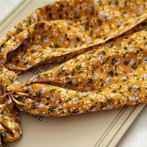 Detail of yellow floral ponytail scarf hair tie with white and purple flower patterns