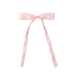 Detailed close-up of a pink satin bow hair clip with long elegant ribbon streamers