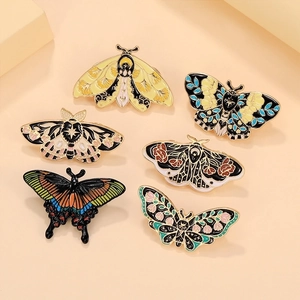 Detailed close-up of six unique butterfly and moth enamel pins on beige background