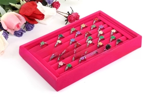 Detail of multi-color gemstone rings in a rose red velvet jewelry display tray