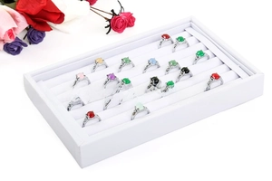 Macro view of multi-color gemstone rings in a white velvet display storage box