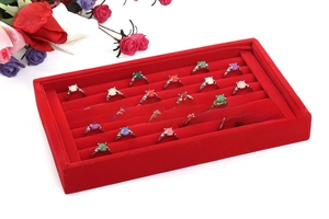 Macro view of a red velvet ring display tray filled with multi-colored gemstone rings