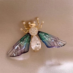 Macro shot of magpie bird brooch with gradient wings and pear-cut crystal detail