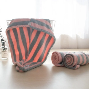 Close-up of pink and grey striped coral fleece facial towel with button fastener