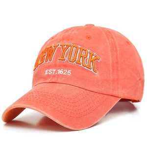 Close-up of orange washed cotton baseball cap with 3D New York embroidery detail