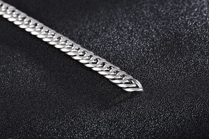 Macro shot of silver titanium steel curb chain bracelet with polished interlocking links