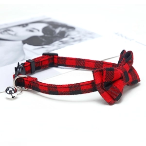 Detail of red and black plaid pet collar with bowknot and silver ringing bell