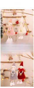 Close-up of plush Christmas angel dolls with sequin wings hanging on a tree branch