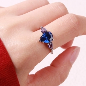 Detailed close-up of a branch-shaped ring with pear-cut blue and purple crystals