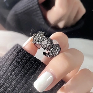 Close-up of black oil-dripped butterfly ring with pavé zircon crystals on a model hand