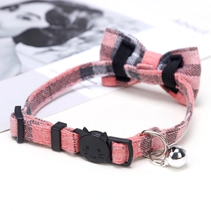 Detail of pink plaid pet collar with a cute bow, black cat buckle and silver bell