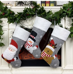 Close-up of three grey felt Christmas stockings with Santa and reindeer embroidery