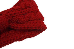 Gros plan sur la maille torsadée rouge d'un bandeau d'hiver épais en laine tricotée