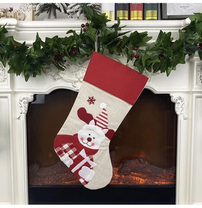 Detailed view of burlap Christmas stockings with elk pattern hanging on a festive fireplace