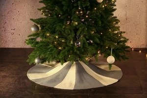 Detail of grey and white knitted Christmas tree skirt with soft textured striped pattern
