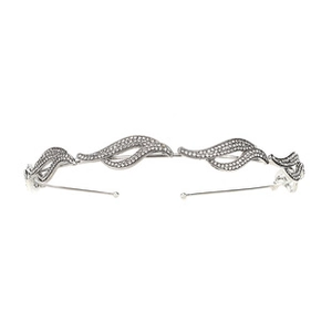 Close-up of wavy silver headband with sparkling green crystals and white rhinestones