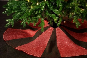 Detailed view of red and black striped knitted Christmas tree skirt with ribbed texture