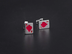 Macro shot of silver poker Ace studs with red oil-drop details and metallic finish