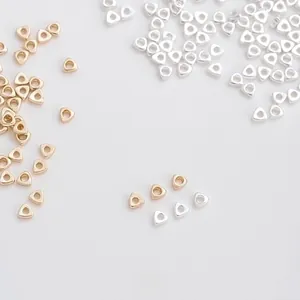 Detailed view of 2mm triangle gold and silver spacer beads for DIY jewelry making