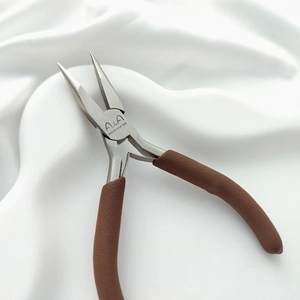 Close-up of needle-nose pliers with brown non-slip handle for professional jewelry making