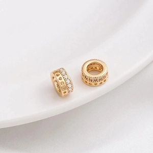 Macro shot of 14K gold plated wheel spacers with sparkling zircon and heart cutouts