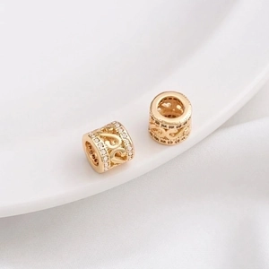 Macro detail of 14K gold plated hollow filigree beads with micro-set zircon stones
