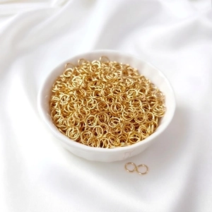 Macro shot of 18K gold plated jump rings in a ceramic bowl for DIY jewelry making