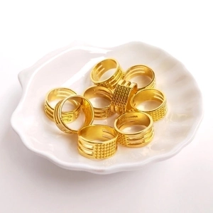 Polished gold textured copper ring tools and accessories displayed on white ceramic