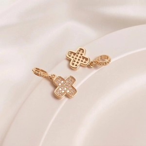 Macro view of gold 14K cross pendant featuring micro-pave zircons and textured bail