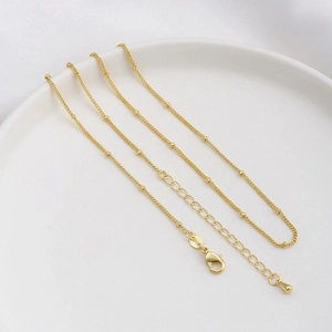 Detail of 14K gold plated chain with spacer beads, lobster clasp and water drop pendant