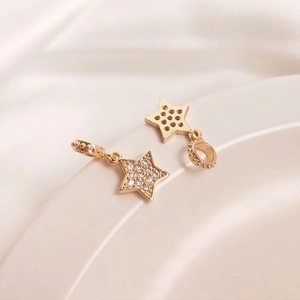 Macro detail of 14K gold plated star pendants with white zircon pavé and honeycomb back