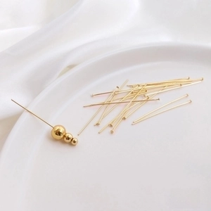 Makrofoto von 14K vergoldeten T-Stiften mit glatten Perlen für DIY-Schmuckherstellung
