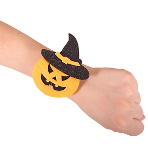 Halloween pumpkin snap bracelet with felt witch hat decor worn on a wrist over white background