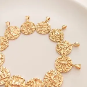 Set of twelve 14K gold-plated zodiac pendants in a circular arrangement on a plain background