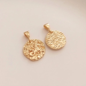 Detailed macro view of 14K gold Capricorn pendant with embossed stars and water ripple texture