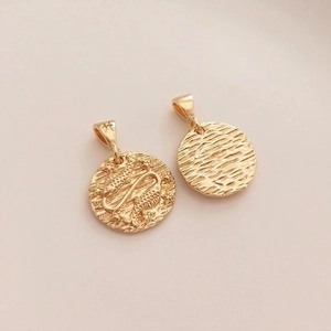 Detail showing 14K gold plated Pisces zodiac pendants with embossed stars and fish symbols