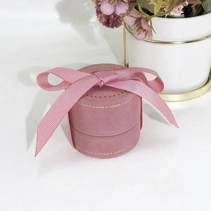 Close-up of pink velvet jewelry box with gold trim and textured ribbon bow