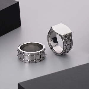 Men's punk style stainless steel rings with rivet design on a minimalist grey background