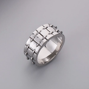 Detailed view of silver stainless steel ring featuring industrial rivet textures and polished finish