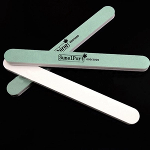 Macro view of 600/3000 grit nail buffer with green and white sides for professional shine