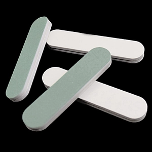 Detailed macro view of 5-piece thick green and white nail buffer blocks on black background