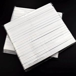 Detailed macro shot of white nail buffer blocks in transparent sealed plastic packaging